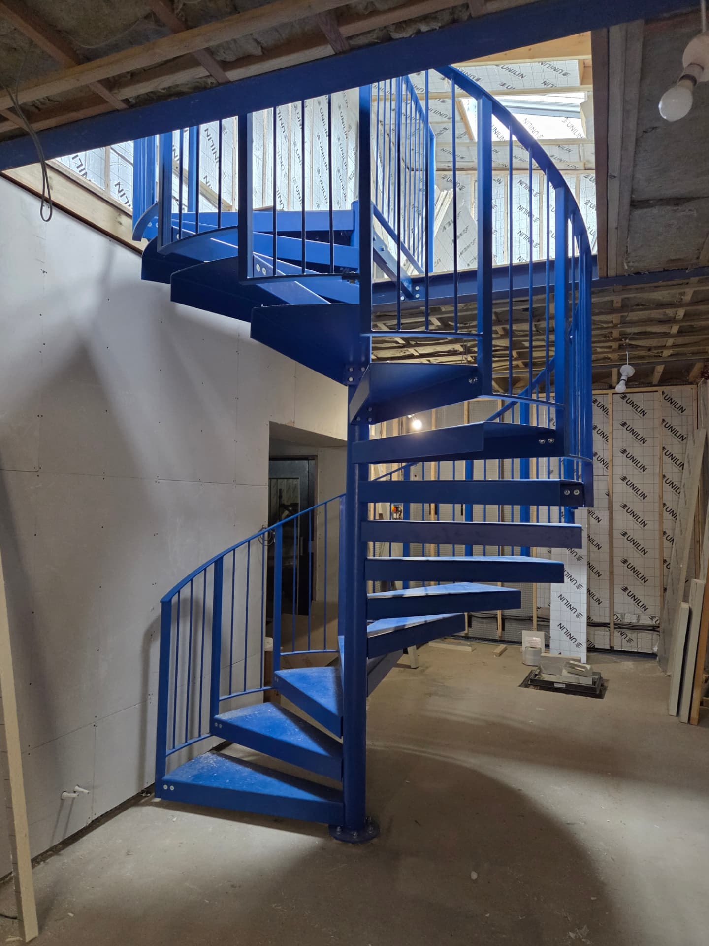 Bespoke blue painted spiral staircase with balustrade installed on site