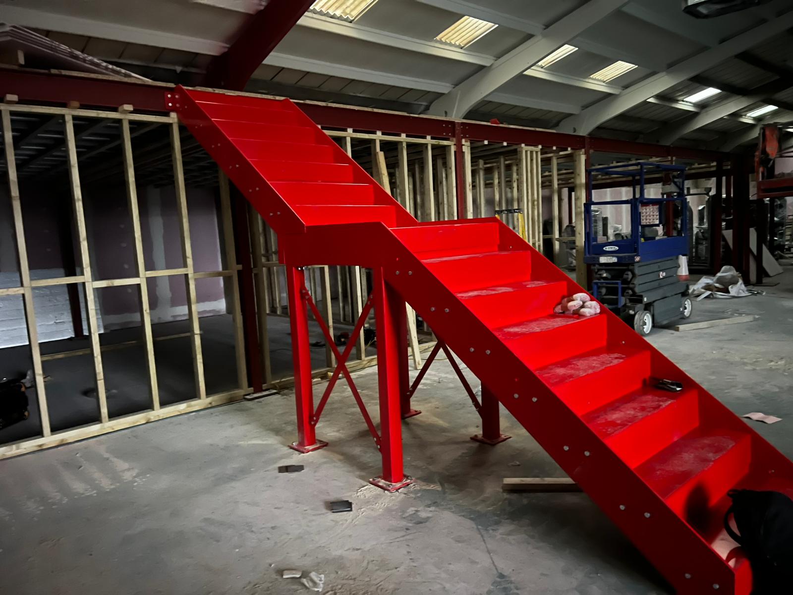 Red-painted bespoke steel staircase fabricated and installed for an office fit-out