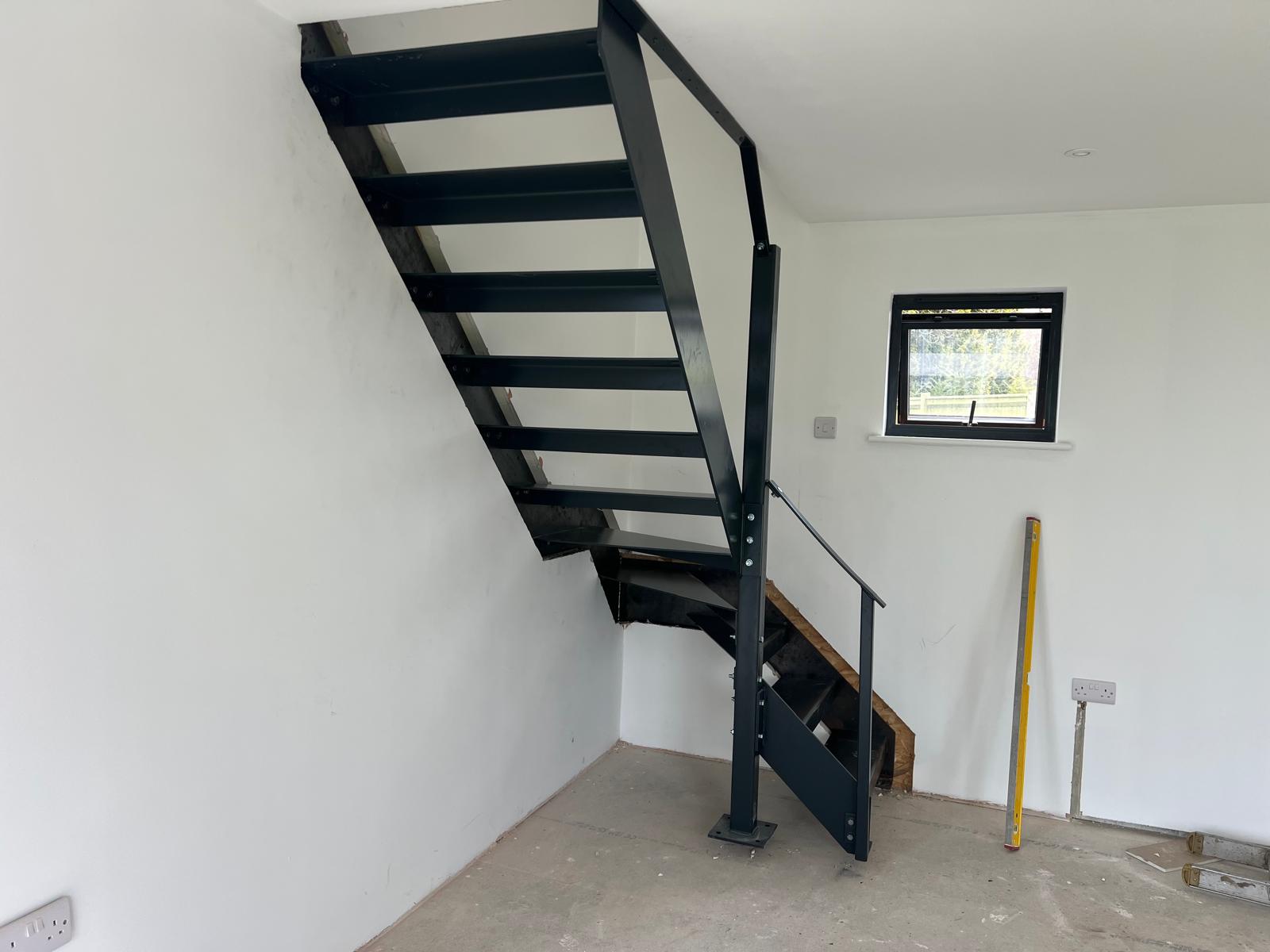 Powder-coated steel staircase with handrail installed in a new home
